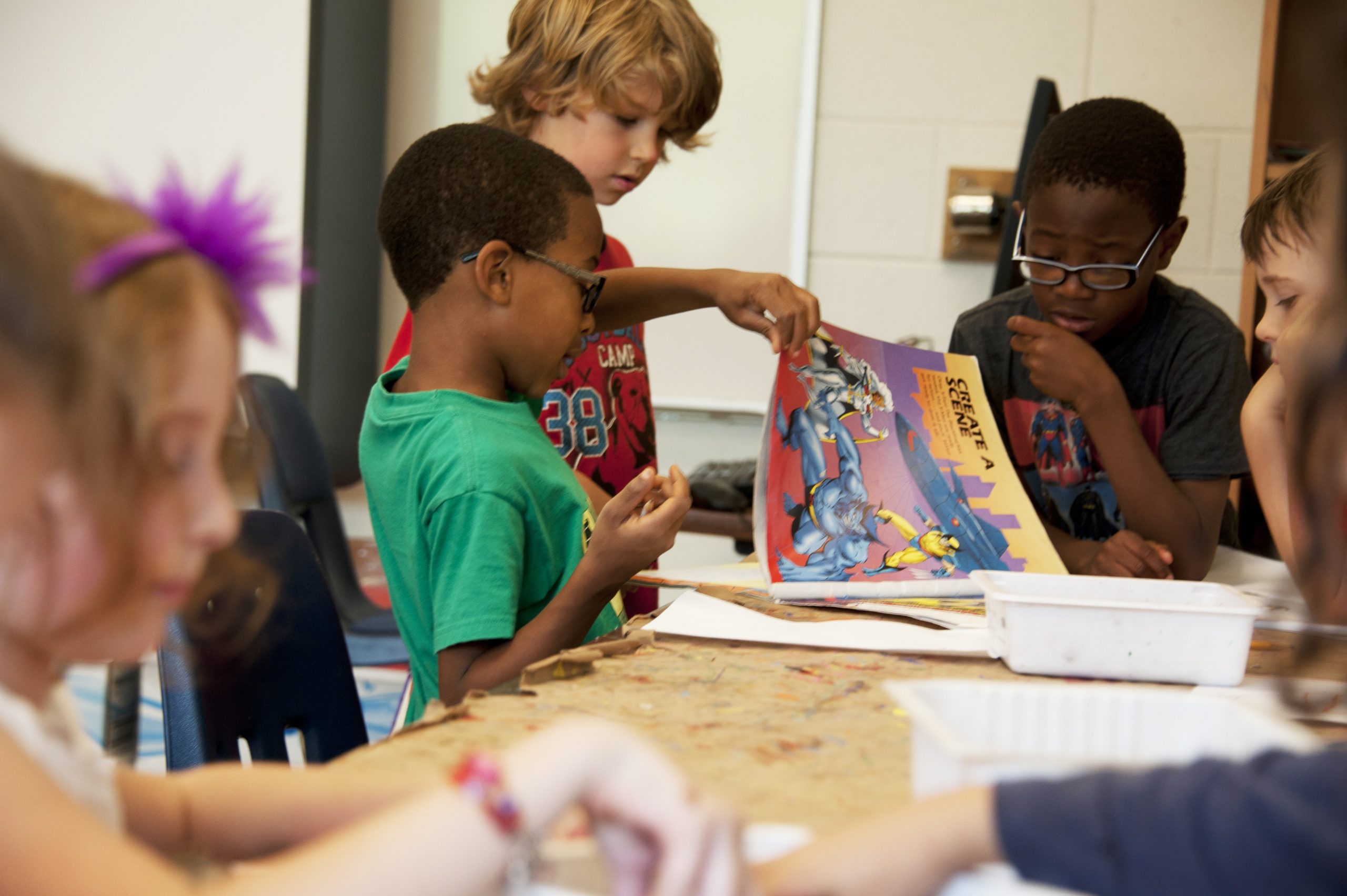 Children working together on projects at long table