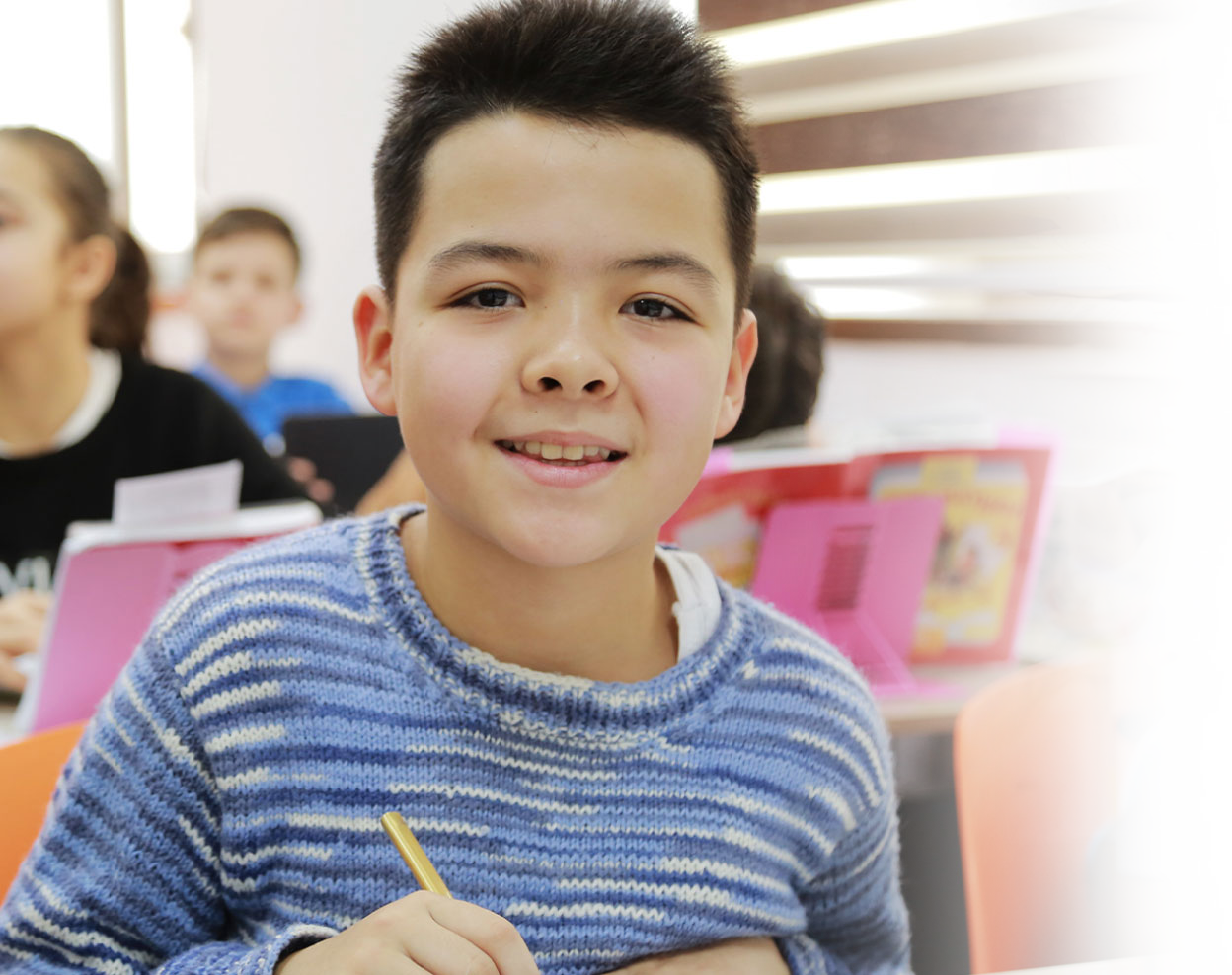 Child poses for camera with pencil in hand